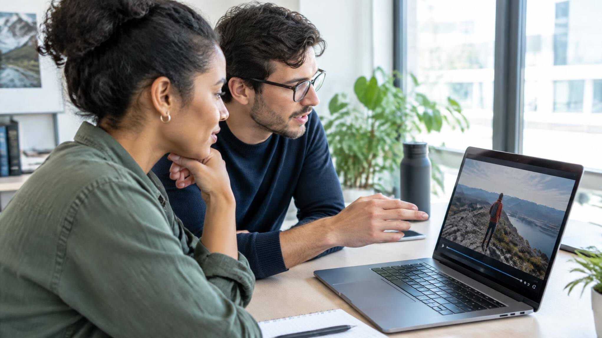 Two colleagues reviewing documentary footage together on a laptop
